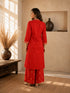 Woman wearing a rust-colored printed cotton kurti and pants set with intricate border details.