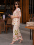 Woman wearing a pink floral print Co ord set, sitting at a table.