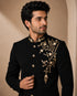 Man wearing a classic black Jodhpuri suit, a traditional Indian formal outfit.