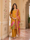 Woman wearing a mustard yellow kurta set with floral prints and palazzo pants, draped with a printed dupatta.