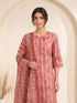 Woman wearing a rose pink printed kurti set with a dupatta, featuring leaf motifs and striped patterns.
