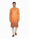 Man wearing an orange embroidered Kurta Pajama with cream pants and brown shoes, showcasing intricate patterns.