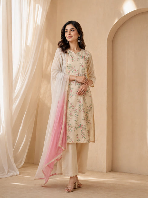 Woman wearing a cream floral print Kurti Set with a pink ombre dupatta and matching pants.