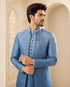 A woman wearing an elegant teal Indowestern outfit, showcasing intricate details and a flattering silhouette.