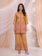 Woman wearing an ochre yellow kurta and palazzo set with a vibrant floral print.