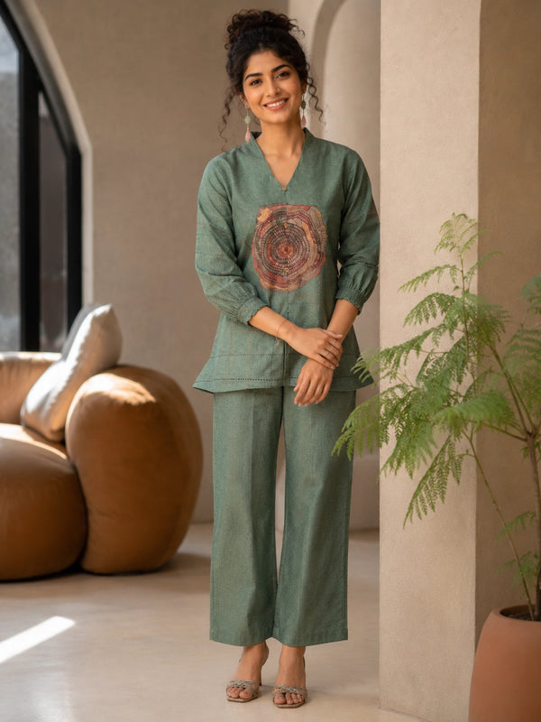 Woman wearing a Pista green co-ord set with a tree ring print top and textured pants.