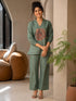 Woman wearing a Pista green co-ord set with a tree ring print top and textured pants.
