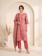 Woman wearing a rose pink printed kurti set with a dupatta, featuring leaf motifs and striped patterns.