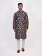 Man wearing a dark multi-color floral print kurta and white churidar pants, traditional ethnic wear.