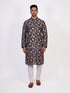 Man wearing a dark multi-color floral print kurta and white churidar pants, traditional ethnic wear.