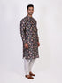 Man wearing a dark multi-color floral print kurta and white churidar pants, traditional ethnic wear.