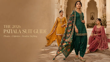 Three Indian women wearing festive Patiala suits with pleated drapes, embroidered kurtis, phulkari dupatta, and ethnic accessories in a luxury haveli courtyard.