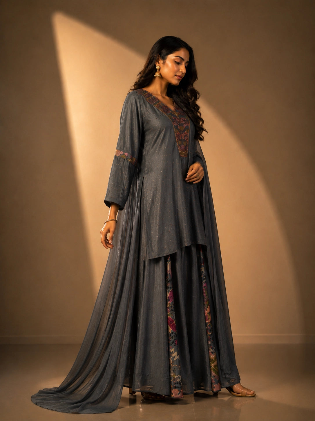 Woman wearing an elegant grey embroidered kurti set with sharara pants and dupatta.