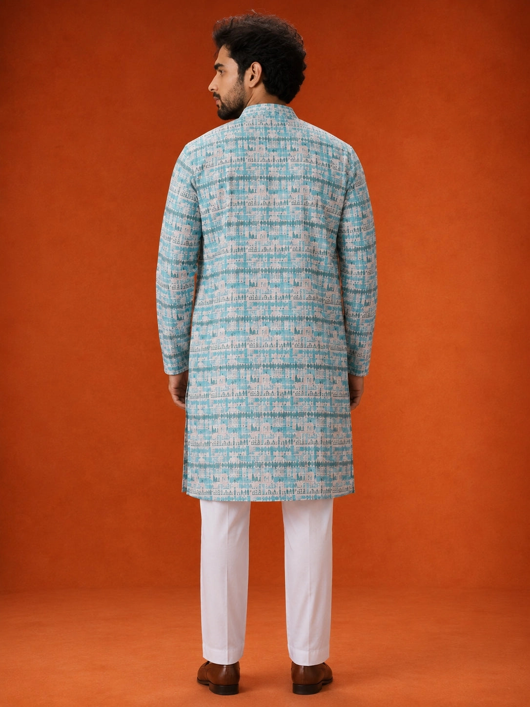 Man wearing an aqua and white printed kurta with white pajamas and brown loafers.