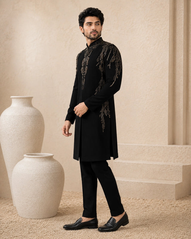 Man wearing a stylish black Indo-Western suit, showcasing intricate details and a modern fit.