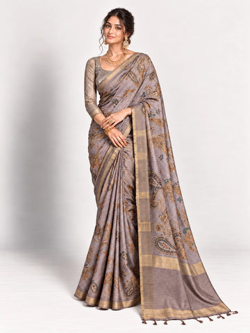 Woman in an elegant lavender grey saree with gold border and intricate paisley patterns.