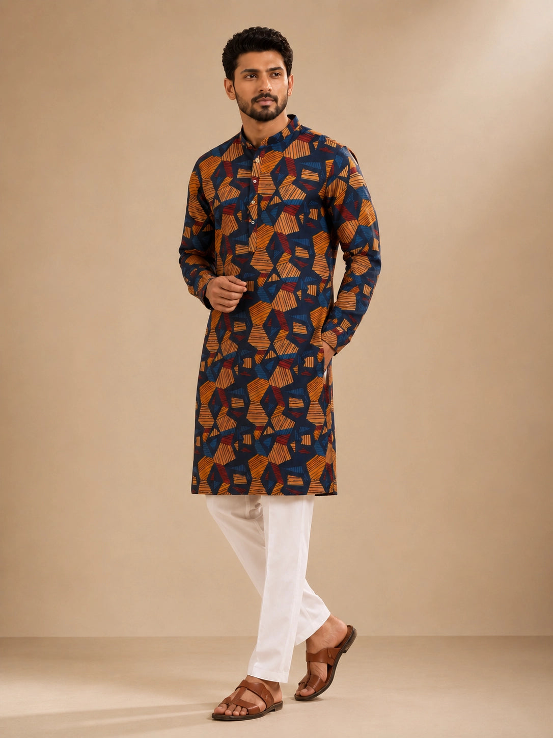Men's navy kurta with geometric print, paired with white pajama bottoms and brown sandals.