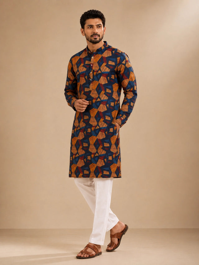 Men's navy kurta with geometric print, paired with white pajama bottoms and brown sandals.