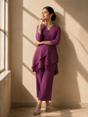 Woman wearing a purple striped V-neck top with layered hem and matching wide-leg pants.