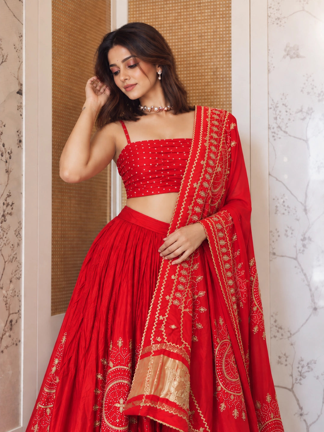 Woman in vibrant red lehenga choli with gold embroidery and matching dupatta.