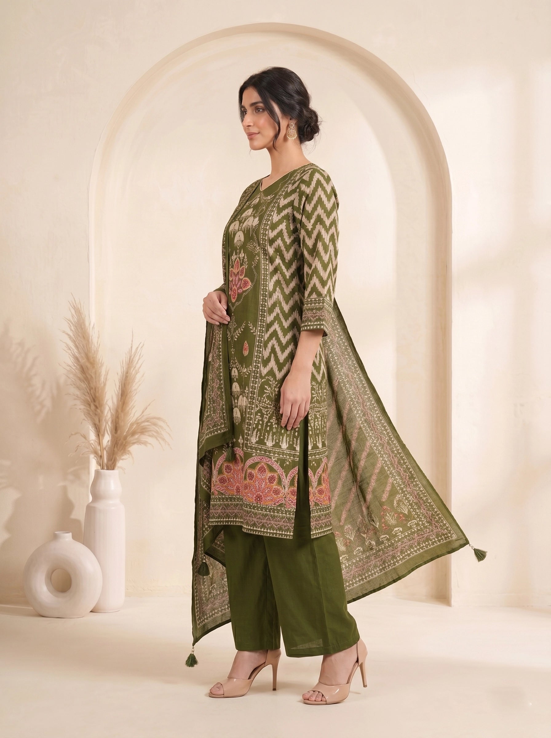 Woman wearing an olive green printed kurti set with palazzo pants and a matching dupatta.