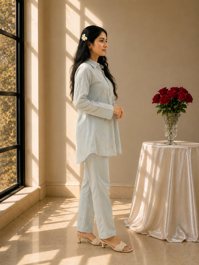 Woman in sky blue floral embroidered kurta set with matching pants.
