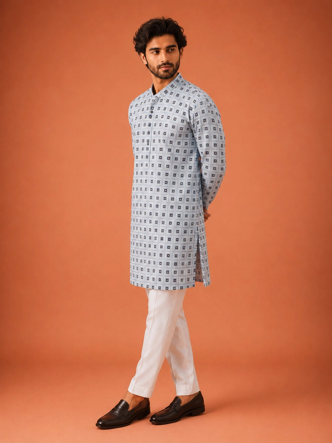Man wearing sky blue geometric print kurta with white pajama and dark loafers.