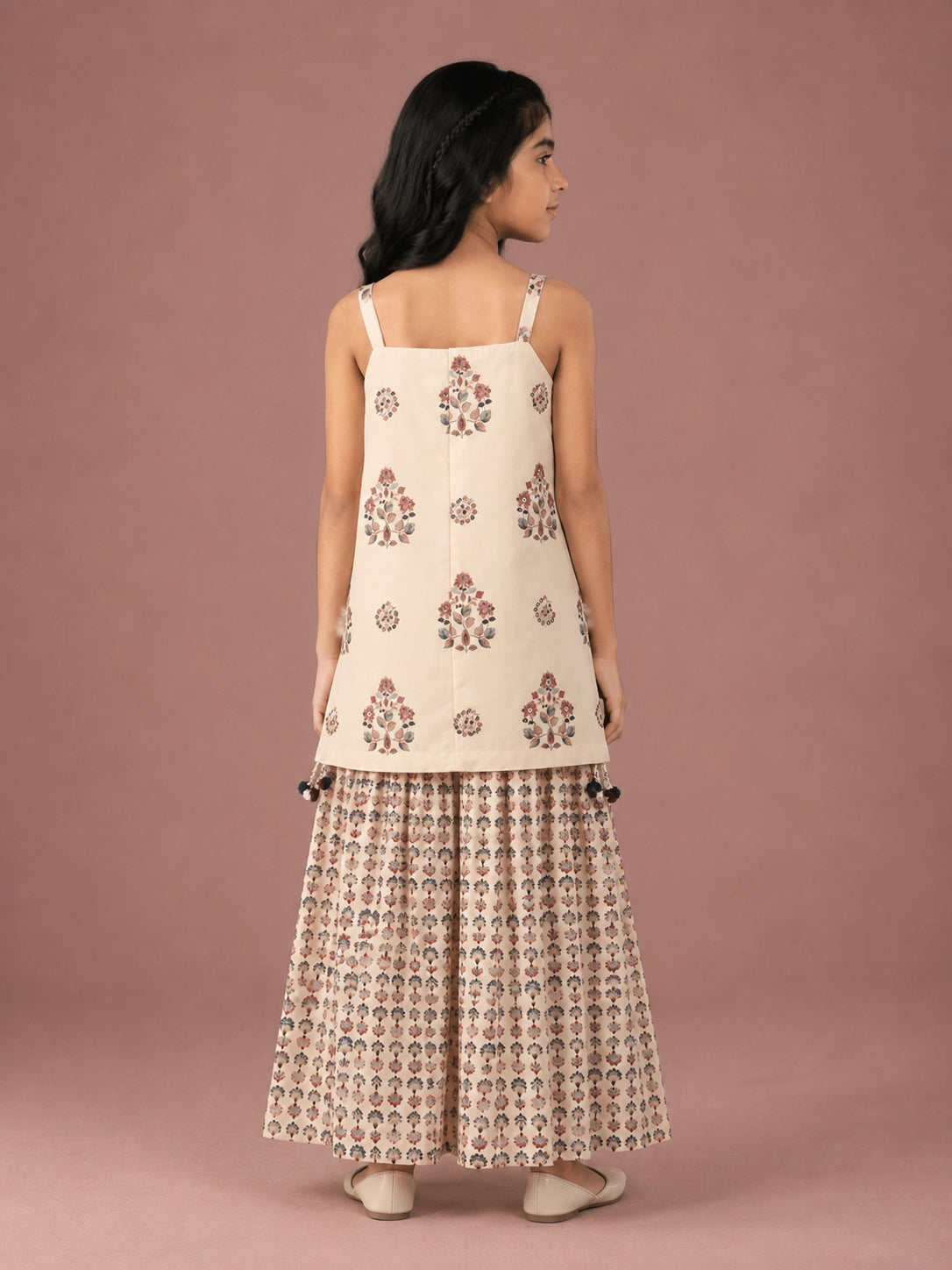 Young girl in a cream floral print strappy top and matching flared sharara set.