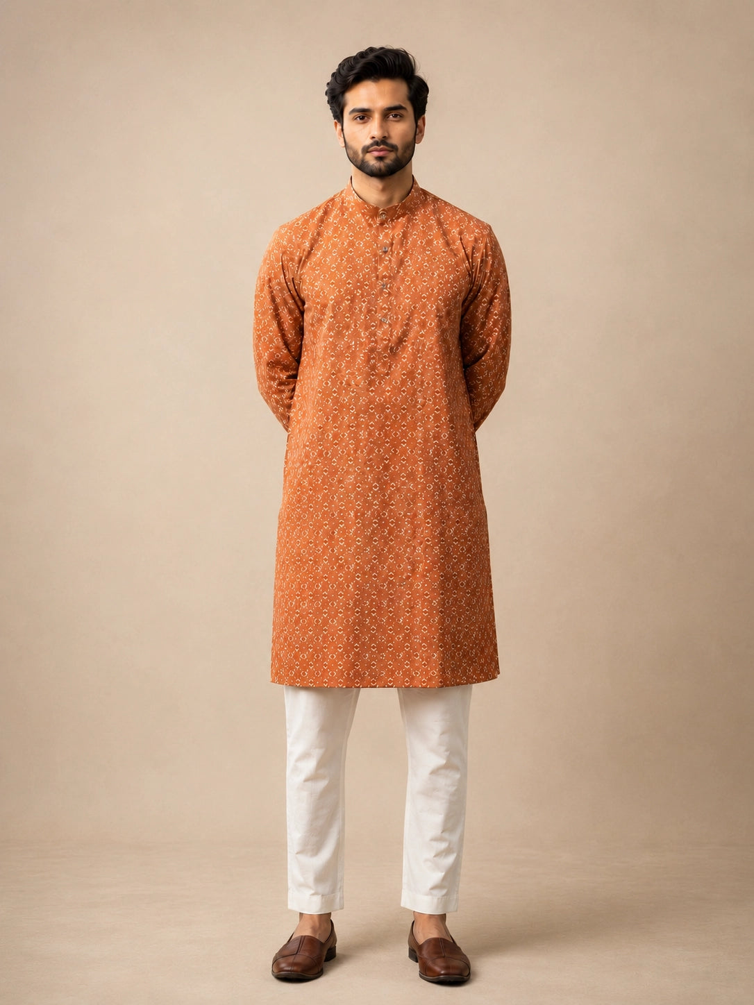 Man wearing a brown printed kurta with a band collar and white pajama.