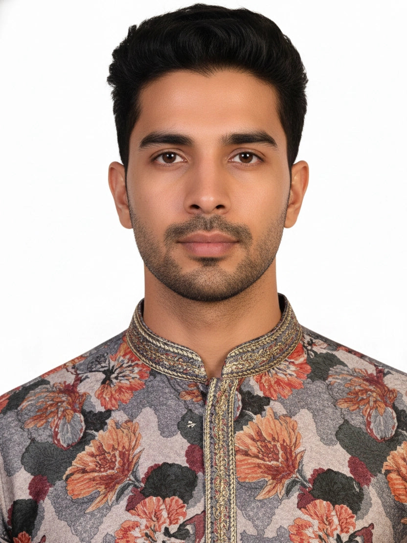 Man wearing a multi-color floral print kurta with an embellished neckline and cream churidar pants.
