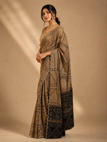 Woman in elegant brown  saree with black geometric print and embellished border.