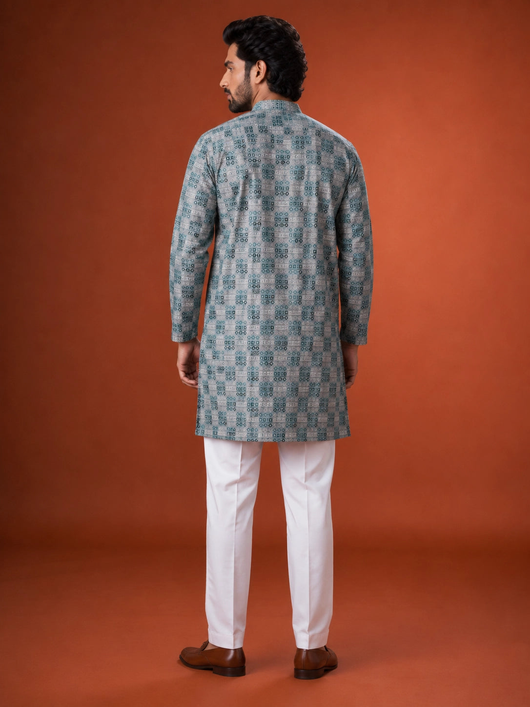 Man wearing a green and grey checkered kurta with white pajama and brown loafers.