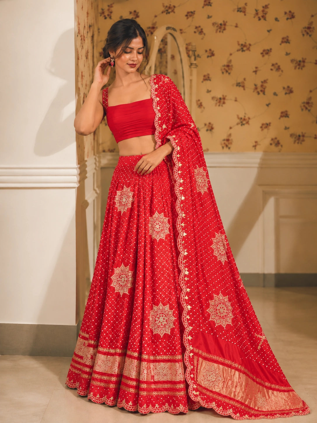 Vibrant red embroidered lehenga choli set with gold patterns and scalloped dupatta.