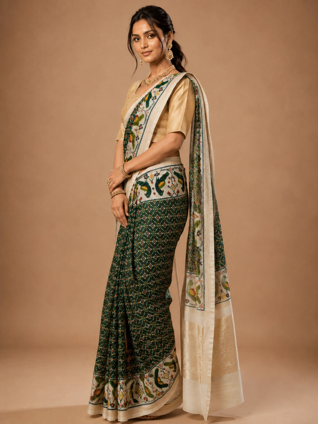 Woman in an elegant green Patola saree with a gold blouse and traditional jewelry.