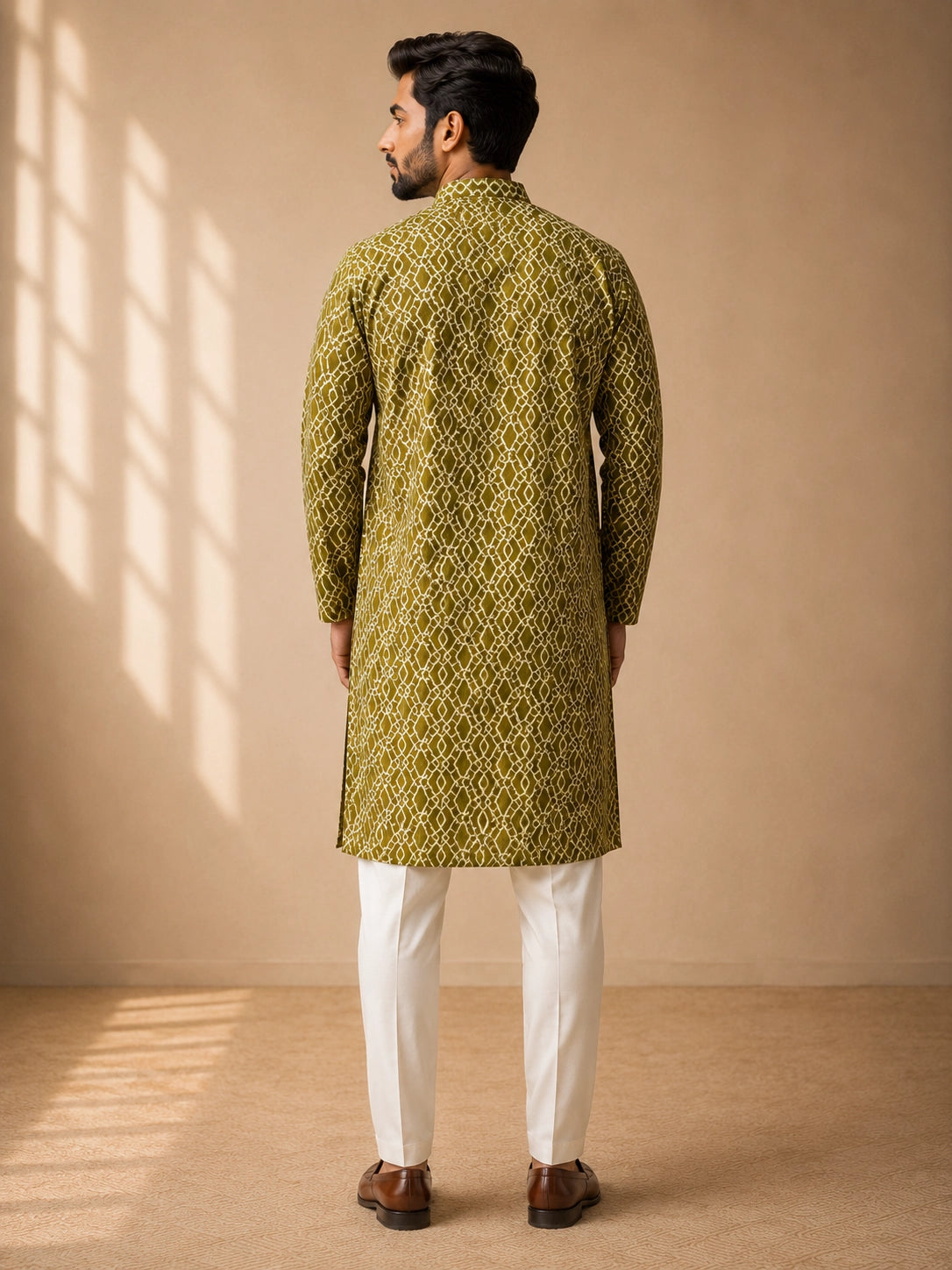 Man in a green patterned kurta with a band collar and white pajama.