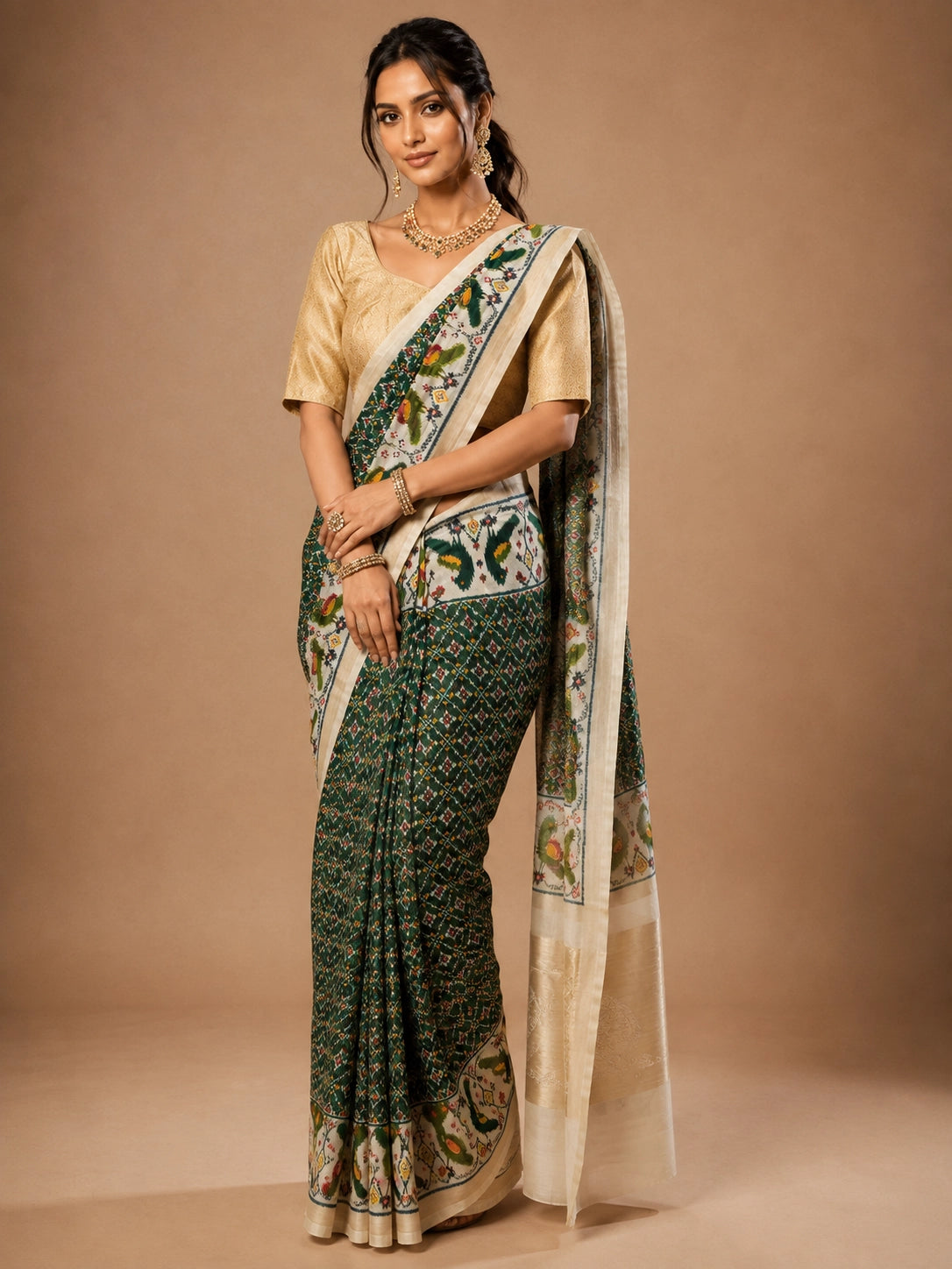 Woman in an elegant green Patola saree with a gold blouse and traditional jewelry.