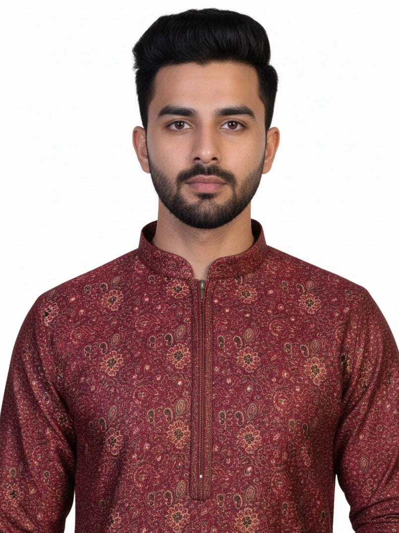 Man wearing a maroon printed kurta with white pants and brown shoes, showcasing traditional Indian attire.