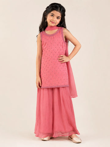 Young girl in a pink sleeveless kurta with beaded embroidery and flowy pink sharara pants.