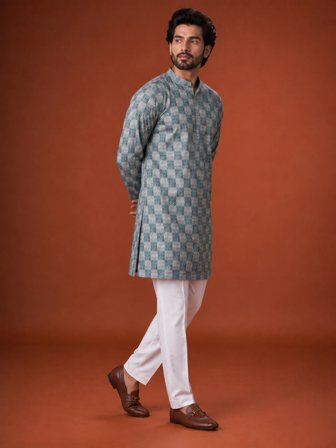 Man wearing a green and grey checkered kurta with white pajama and brown loafers.