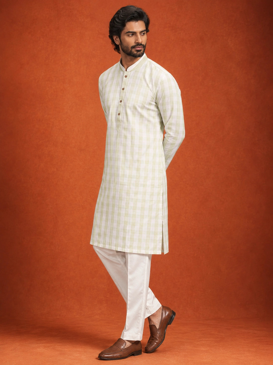 Full-length view of a man in a pista green checkered kurta and white pajama.