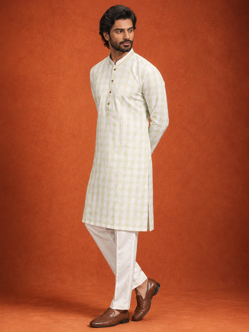 Full-length view of a man in a pista green checkered kurta and white pajama.