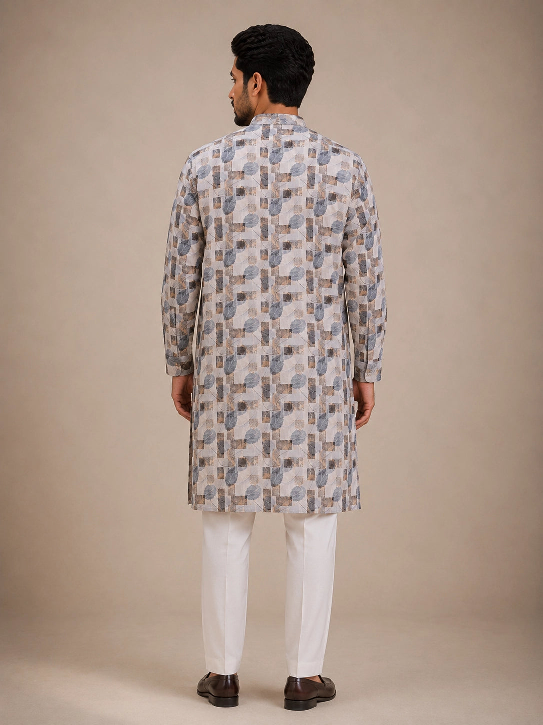 Man wearing an ice grey printed kurta with white pajama and brown loafers.