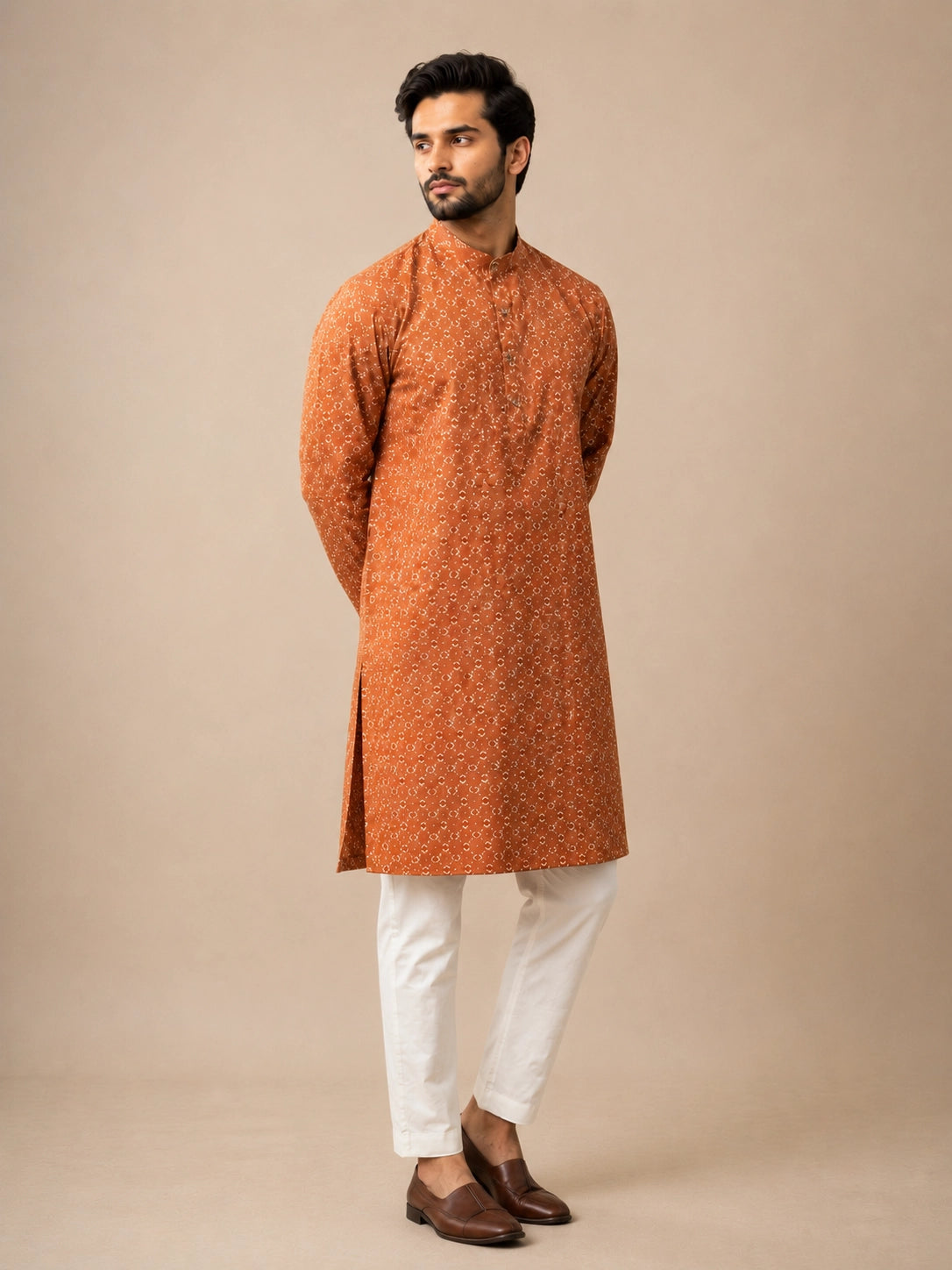 Man wearing a brown printed kurta with a band collar and white pajama.