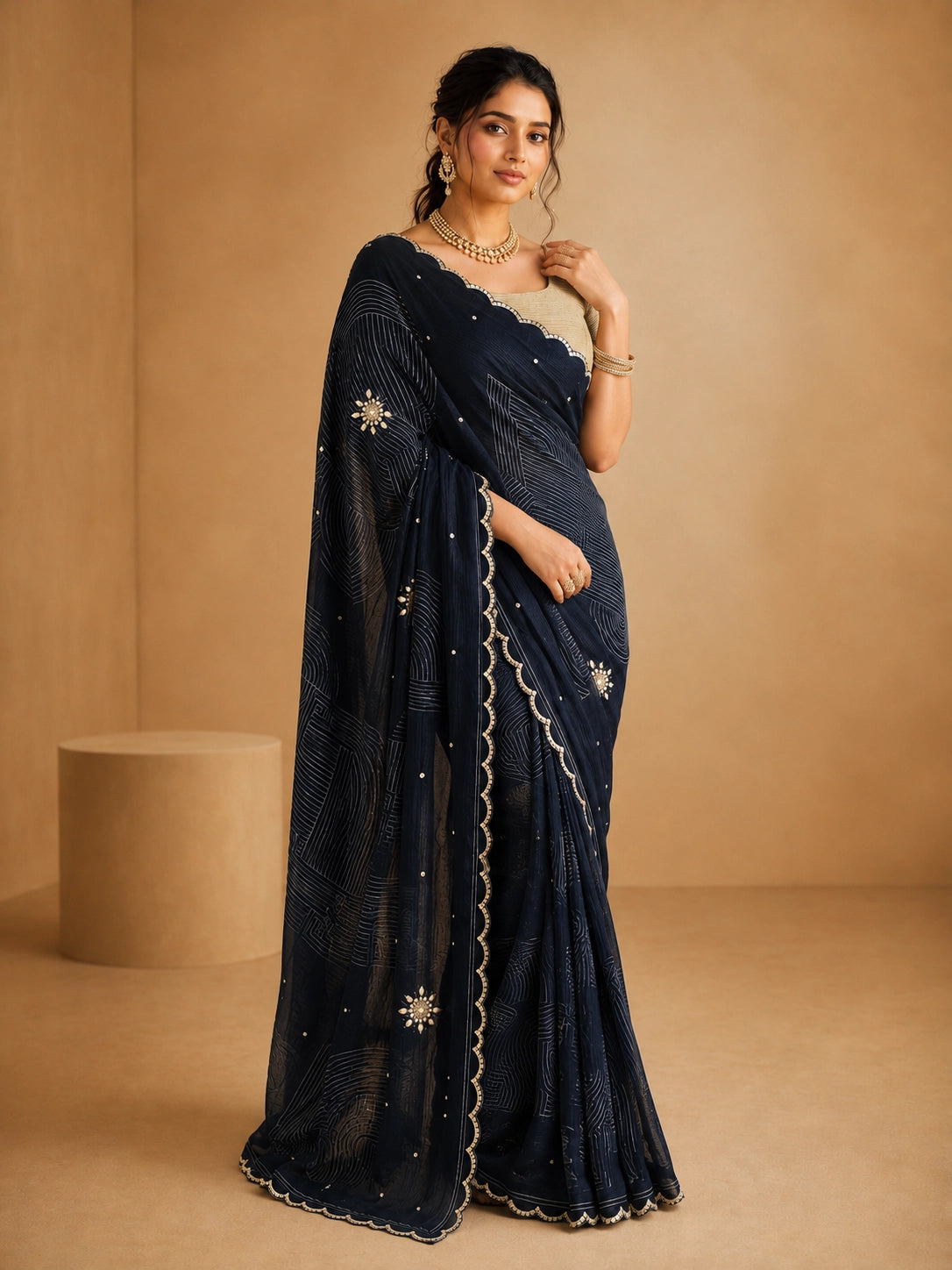 Woman wearing an elegant navy blue embroidered saree with a golden blouse and traditional jewelry.