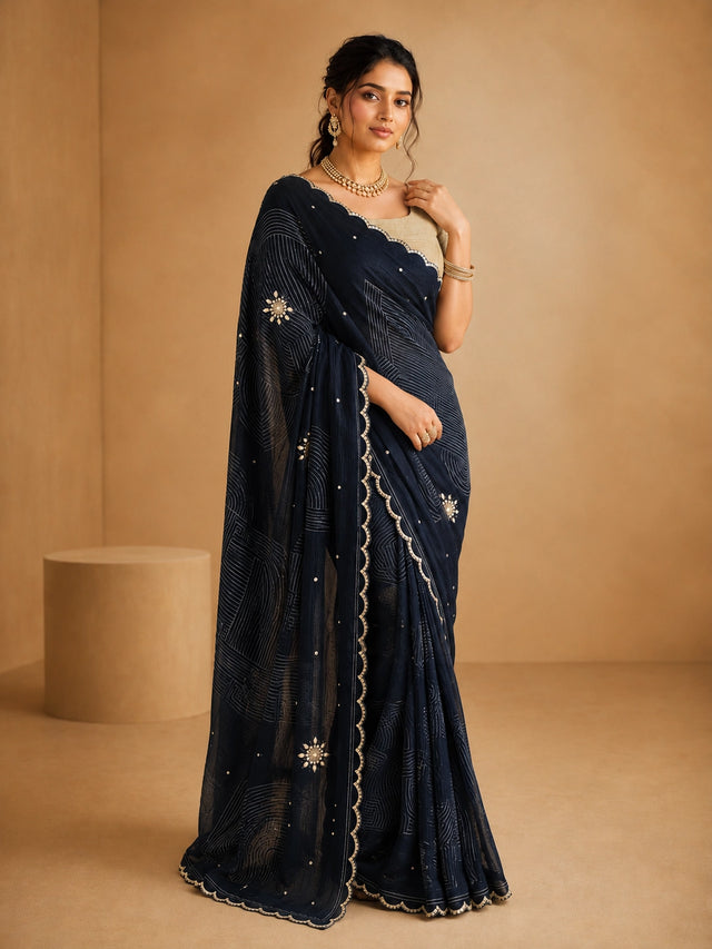 Woman wearing an elegant navy blue embroidered saree with a golden blouse and traditional jewelry.