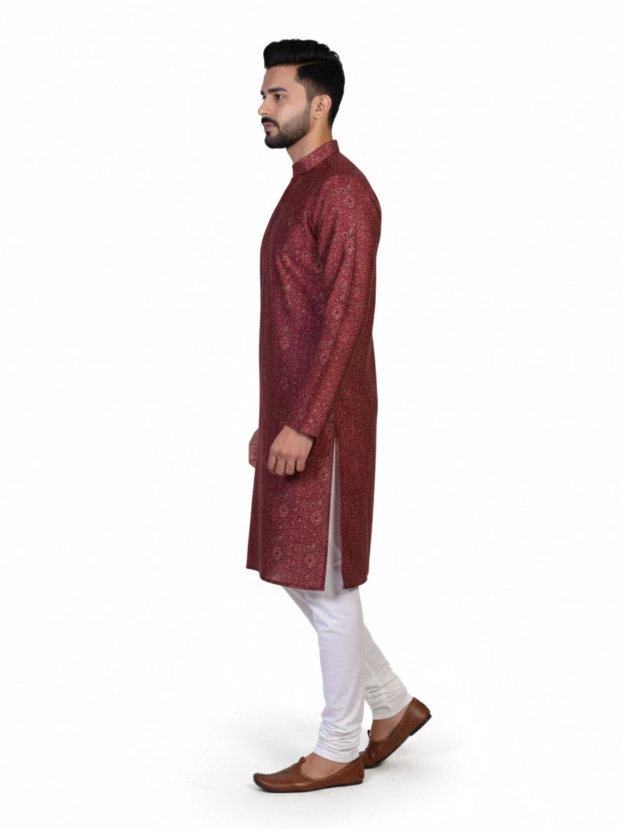 Man wearing a maroon printed kurta with white pants and brown shoes, showcasing traditional Indian attire.