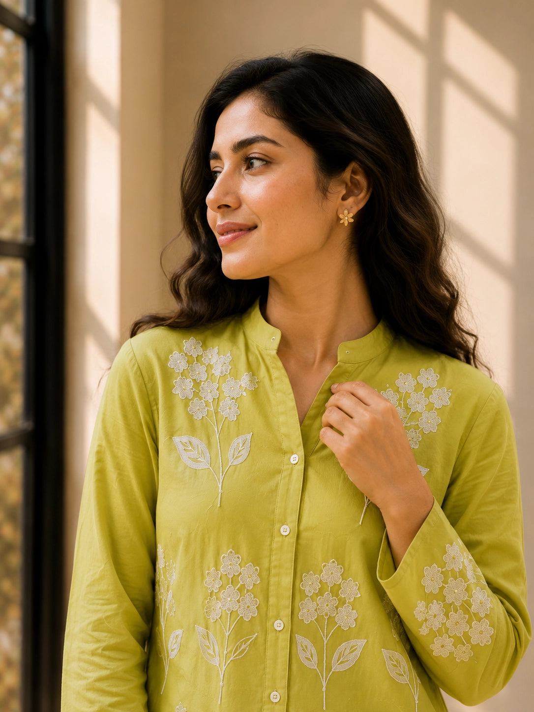 Woman in pista green embroidered tunic kurti and white trousers, smiling.