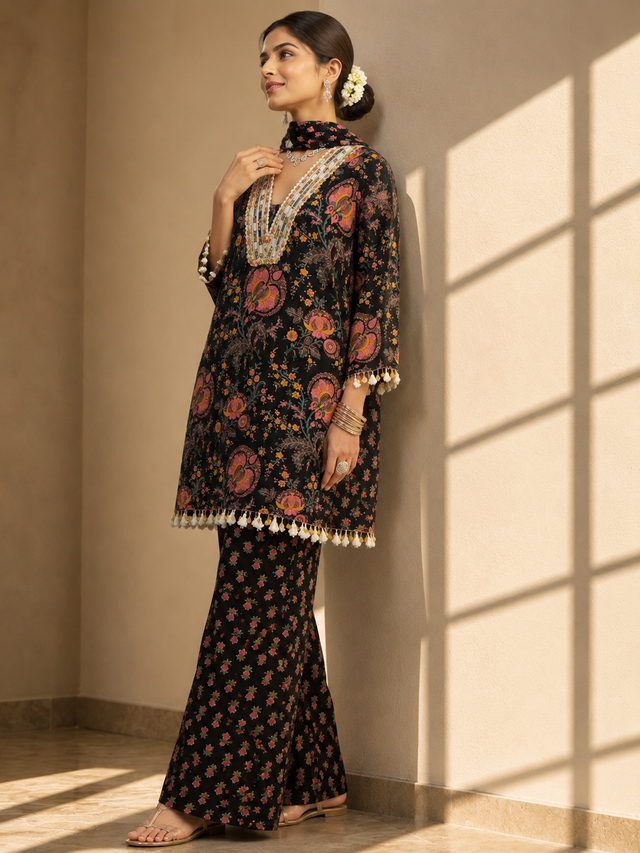 Woman in a black floral kurti set with embroidered V-neck and matching palazzo pants.