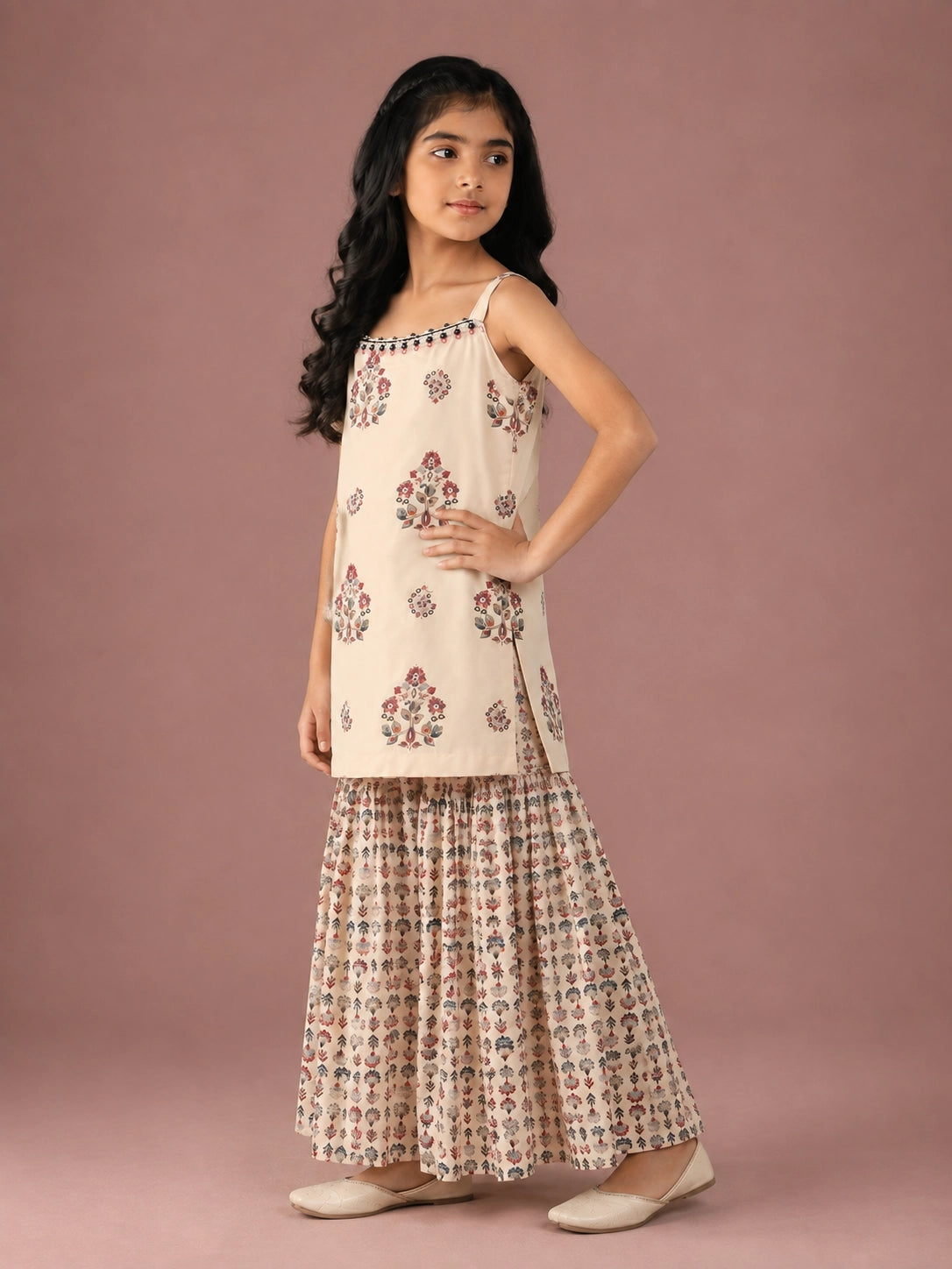 Young girl in a cream floral print strappy top and matching flared sharara set.