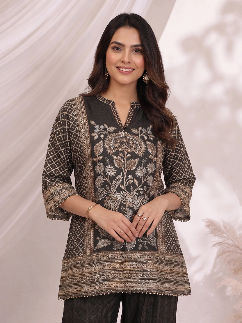 Woman wearing a black printed kurta with wide-leg pants, featuring floral motifs and a contrasting border.
